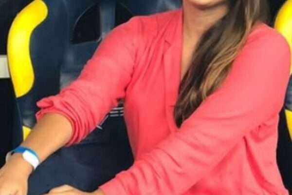 Raísa Simplício sentada em banco de reservas, em uma pausa do trabalho.